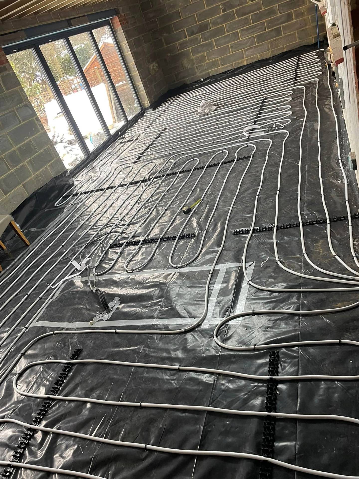 Underfloor heating in new extension with block work walls and bifold door. — Philbert Construction extensions project in Reading