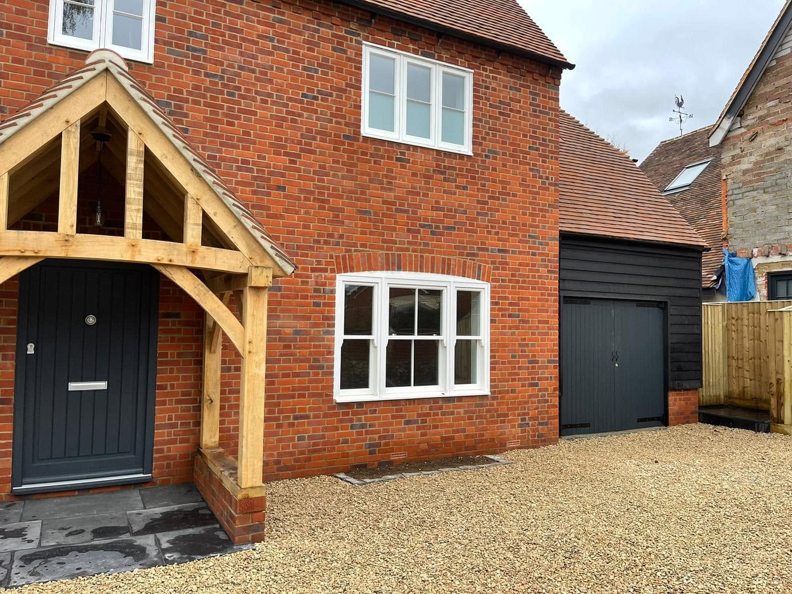 New build house with gravel driveway and wooden porch